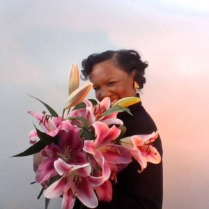 Tiffany Nicole Fletcher is smiling and holding lilies in her arms.